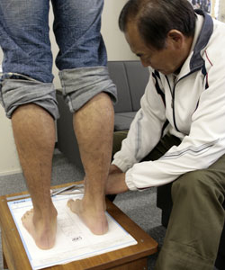 足型計測用紙の上で専用の道具を使って足型を計測。