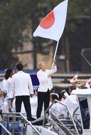 パリ五輪の開会式で、セーヌ川をパレードする船上で日の丸を振る旗手の江村美咲＝２６日、パリ（代表撮影・共同） 