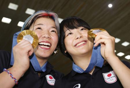 パリ五輪で獲得した金メダルを手に笑顔を見せる、レスリング女子の藤波朱理（右）と鏡優翔＝１２日、パリ近郊のシャルル・ドゴール空港（共同）