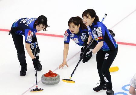  女子１次リーグの札幌国際大戦でショットを放つロコ・ソラーレの吉田知（奥）＝横浜ＢＵＮＴＡＩ
        