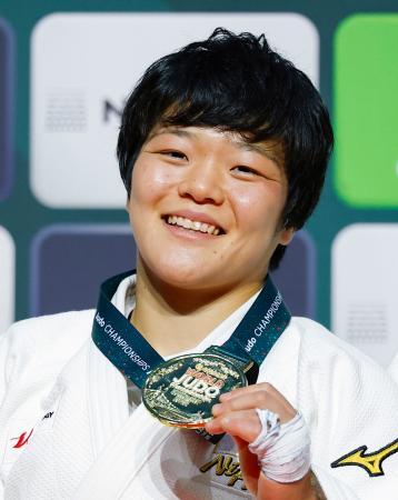 柔道の世界選手権女子６３キロ級で初出場優勝を果たし、金メダルを手に笑顔を見せる嘉重春樺＝１６日、ブダペスト（共同）