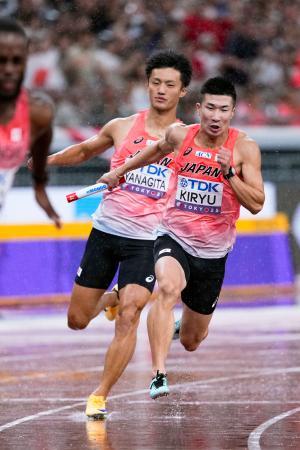 男子４００メートルリレー決勝　２走の柳田大輝（左）からバトンを受け、力走する３走の桐生祥秀＝国立競技場