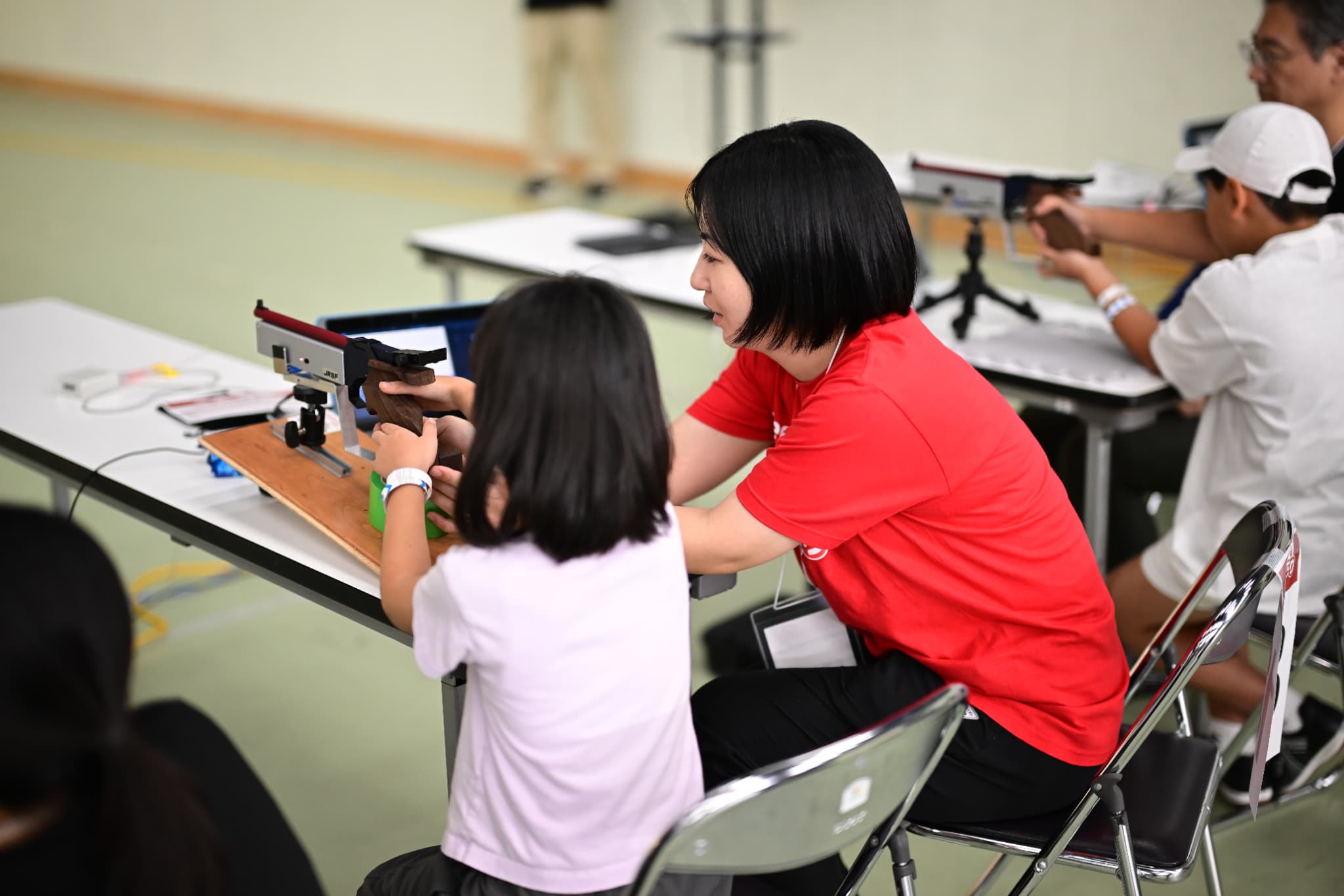 射撃体験教室で指導をする相澤ひかる選手(写真:アフロスポーツ)