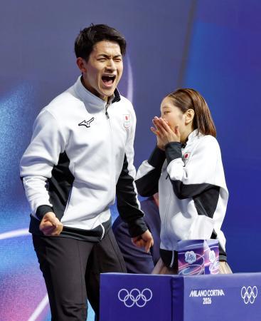 ペア・フリーの得点を確認し、驚く三浦璃来（右）とガッツポーズする木原龍一＝ミラノ（共同）