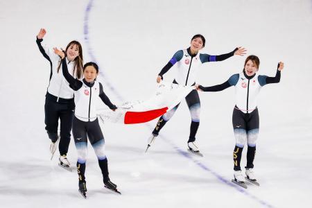 女子団体追い抜きで銅メダルを獲得し、日の丸を掲げ場内を回る（左から）堀川桃香、高木美帆、野明花菜、佐藤綾乃＝ミラノ（共同）