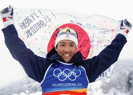 最後の五輪を終え、応援メッセージが書かれた日の丸を掲げるノルディックスキー複合男子の渡部暁斗＝１９日、テーゼロ（共同）