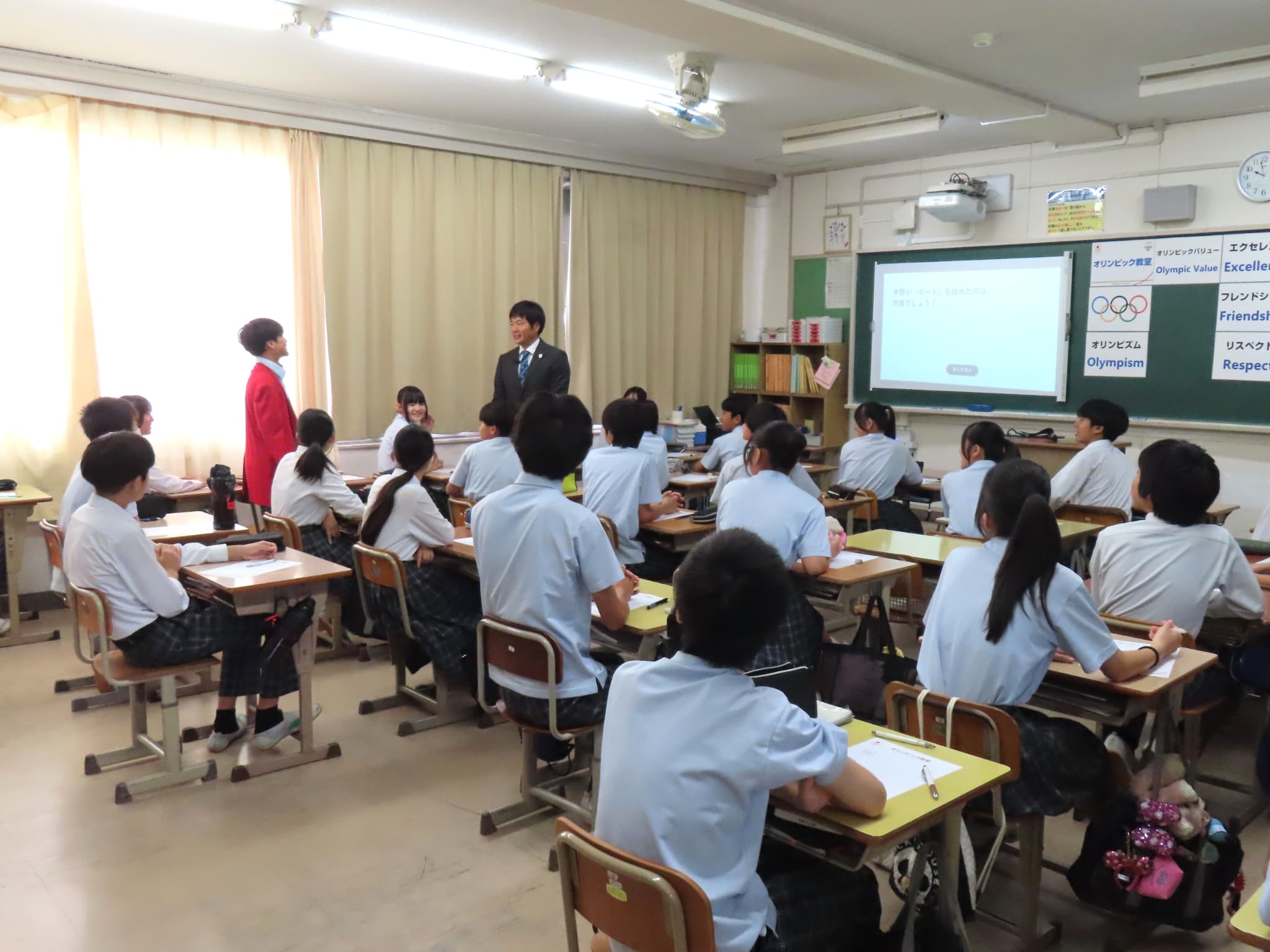 質問には赤のオリンピックウエアを着て答える